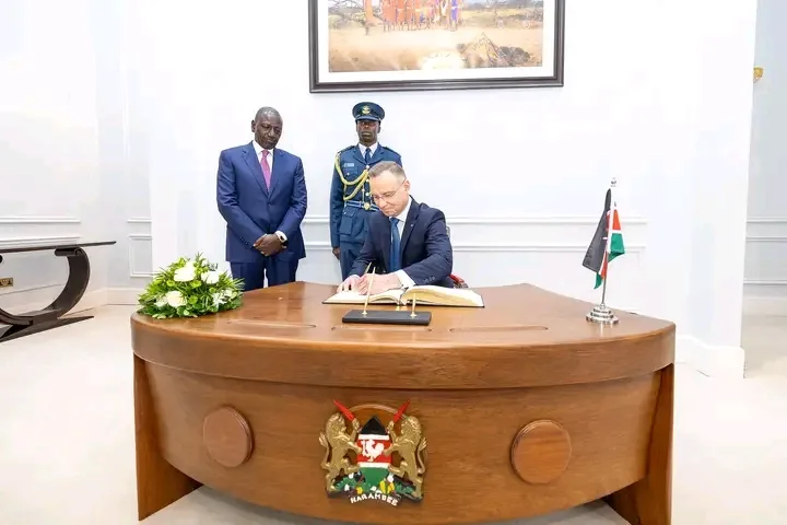 Kenyan President witnessing Poland President as he signs a document